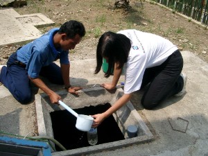 排水処理プラントで水質調査のための水を採取する